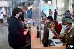 Para wisatawan manca negara di aula kedatangan internasional Bandara Internasional Ngurah Rai di Tuban dekat Denpasar, Bali, 16 Februari 2022. (Foto: SONNY TUMBELAKA / AFP)