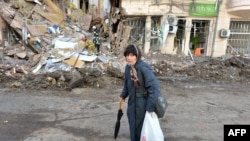 Rescuers remove debris from a building damaged by shelling in central Kharkiv on March 16, 2022, amid Russia's invasion of Ukraine.