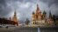 FILE - A woman walks near the Kremlin and St. Basil's Cathedral in central Moscow, Russia, Feb. 22, 2022. 