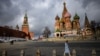 FILE - A woman walks under cloudy skies near the Kremlin and St. Basil's Cathedral in central Moscow, Russia, Feb. 22, 2022. 