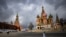 FILE - A woman walks near the Kremlin and St. Basil's Cathedral in central Moscow, Russia, Feb. 22, 2022. 