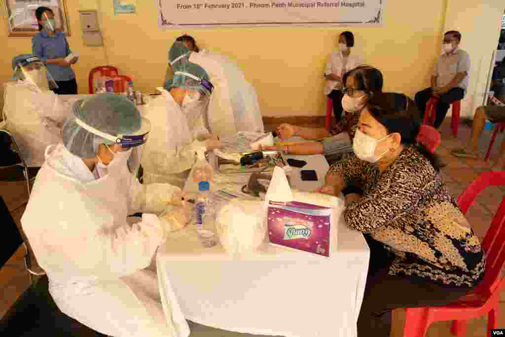 ប្រជាពលរដ្ឋដែលមានអាយុ ៦០ឆ្នាំឡើង បានមកទទួលការចាក់វ៉ាក់សាំងការពារជំងឺកូវីដ១៩ របស់ក្រុមហ៊ុន AstraZeneca នៅមន្ទីរពេទ្យបង្អែករាជធានីភ្នំពេញ កាលពីថ្ងៃទី២៣ ខែមីនា ឆ្នាំ២០២១។ (ទុំ ម្លិះ/វីអូអេ)