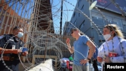 An U.S. Customs and Border Protection agent listens to Russians seeking for a humanitarian visa at the San Ysidro Port of Entry of the US-Mexico border in Tijuana, Mexico, March 15, 2022. 