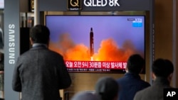 Orang-orang menonton layar TV yang menampilkan program berita yang melaporkan tentang rudal Korea Utara dengan rekaman file, di sebuah stasiun kereta api di Seoul, Korea Selatan, Rabu, 16 Maret 2022. (Foto: AP)