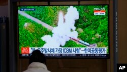 Seorang pengunjung menonton layar TV yang menayangkan berita tentang rudal Korea Utara di sebuah stasiun kereta api di Seoul, Korea Selatan, Jumat, 11 Maret 2022. (Foto: AP)