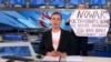 A video grab shows Russian Channel One editor Marina Ovsyannikova holding a poster that reads "Stop the war. Don't believe the propaganda. They are lying to you here" during a live evening news broadcast, in Moscow, March 14, 2022.