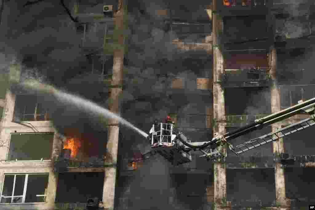 Firefighters extinguish a fire in an apartment building damaged by Russian shelling in Kyiv, Ukraine, March 15, 2022. Russia&rsquo;s offensive in Ukraine has edged closer to central Kyiv with a series of strikes hitting a residential neighborhood as the leaders of three NATO member countries planned a visit to the embattled capital.