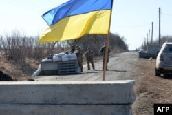 Servicemen of Ukrainian military forces guard a checkpoint, where they hold a position near Kharkiv, March 23, 2022.