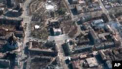 This satellite photo provided by Maxar Technologies March 19, 2022, shows the aftermath of an airstrike earlier in the week on the Mariupol Drama Theater, in Mariupol, Ukraine, and the area around it.
