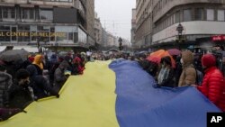 Arhiva - Ljudi nose džinovsku zastavu Ukraine tokom protiesta protiv ruske agresije na Ukrajinu, u Beogradu, Srbija, 6. marta 2022. (AP Photo/Marko Drobnjakovic)