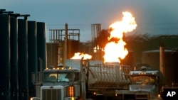 Sejumlah truk tangki tampak mengantri di dekat sumber gas alam di Williston, North Dakota, pada 9 Juni 2014. (Foto: AP/Charles Rex Arbogast)