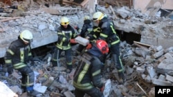 This handout picture taken and released on March 22, 2022, by the Ukrainian State Emergency Service shows rescuers conducting search operations and dismantling debris in Kharkiv.