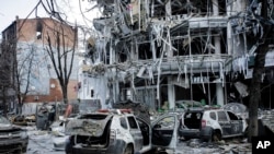 FILE - Damaged vehicles and buildings in Kharkiv city center in Ukraine, March 16, 2022.