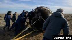 Arhiva - Spasioci stižu do kapsule Sojuz MS-19 u kojoj su članovi posade sa Međunarodne svemirske stanice, NASA-in Mark Vende Hej i Roskosmosovi Anton Škaplerov i Pjotr Dobrov, nakon sletanja na Zemlu, u stepi pokraj grada Žezkazgan, u Kazahstanu, 30. marta 2022.