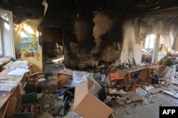 A classroom is littered with debris at a school hit by a Russian air bomb in Kharkiv, Ukraine, March 23, 2022.