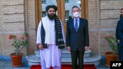 Menteri Luar Negeri Taliban Amir Khan Muttaqi (kiri) bersama Menlu China Wang Yi di Kabul hari Kamis (24/3). 