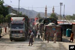 Seorang anggota Taliban berjaga di samping truk yang menunggu untuk menyeberang di titik penyeberangan perbatasan antara Pakistan dan Afghanistan, di Torkham, di distrik Khyber, Pakistan, 21 Agustus 2021. (Foto: AP)