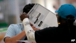 Petugas pemilu memeriksa surat suara di sebuah TPS di Clark County, Las Vegas, Nevada, 10 November 2022.