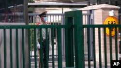 FILE - A paramilitary police officer stands guard outside the German embassy in Beijing, Sept. 6, 2021. 