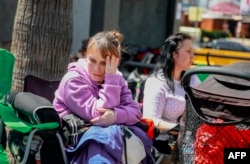 Ukrainian refugees wait to enter the United States at the San Ysidro Port of Entry at the U.S.-Mexico border, in Tijuana, Mexico, April 4, 2022.