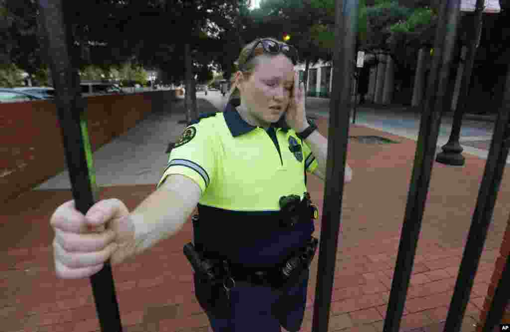 Standing a block away from the shooting scene, Dallas Police Officer Camille Munoz reacts as she talks about her fellow officers killed by a sniper in downtown Dallas, July 8, 2016. 