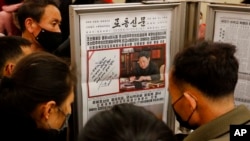 지난해 3월 북한 평양역에서 주민들이 게시된 '로동신문'을 읽고 있다.