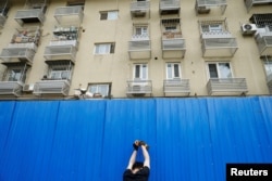 工人在北京市一个居民小区楼外竖起屏障进行封闭。（2022年4月29日）