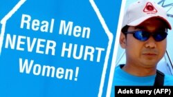 Seorang pria memegang plakat untuk membela perempuan (foto: ilustrasi). Kekerasan terhadap istri selalu menempati urutan pertama dalam kasus KDRT di tanah air. 