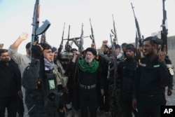 FILE - Iraqi Shiite militia group called Imam Ali Brigades chant slogans against the Islamic State group at the battlefield in Tikrit, 130 kilometers (80 miles) north of Baghdad, Iraq, March 14, 2015.