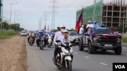 សកម្មជន​គណបក្សប្រជាជនកម្ពុជា ធ្វើការហែក្បួនឃោសនារកសំឡេង​ឆ្នោត នៅតាមដងផ្លូវក្នុងរាជធានីភ្នំពេញ នៅថ្ងៃទី​២១ ខែឧសភា ឆ្នាំ២០២២។ (លាស់ លីបលីប/វីអូអេ)