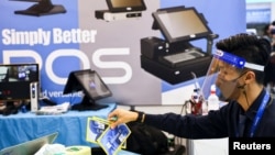 台湾一名戴着口罩和面罩的工作人员在为台北国际电脑展览会开幕做准备。（2022年5月24日）