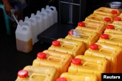 Seorang petugas mengisi jerigen dengan minyak goreng di sebuah stasiun distribusi di Jakarta, 20 Mei 2022. (REUTERS/Willy Kurniawan)