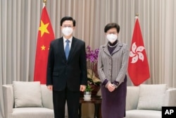 香港新特首李家超与前任林郑月娥在政府大楼。(美联社，2022年5月9日)