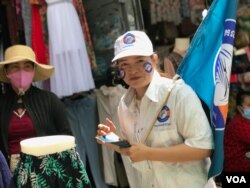 អ្នកគាំទ្រ​គណបក្ស​កម្ពុជានិយម​ ដើរ​ចែក​ខិត្តបណ្ណ​គោលនយោបាយ​បក្ស​ក្នុងផ្សារ​មួយ​ ក្នុង​សង្កាត់បឹង​ទំពន់​ទី​២​ រាជធានី​ភ្នំពេញ​ ថ្ងៃ​អាទិត្យ​ ទី​២៩​ ខែឧសភា​ ឆ្នាំ​២០២២។​ (ហ៊ុល រស្មី/វីអូអេ)​