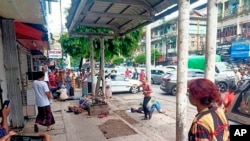 Empat orang yang terluka akibat pemboman di sebuah halte bus tampak tergeletak di sisi jalan di pusat kota Yangon, Myanmar Selasa (31/5). 