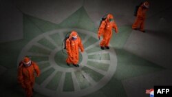 Na fotografiji od 17. maja, koju je 18. maja 2022. objavila severnokorejska zvanična novinska agencija KCNA, vidi se osoblje železničke stanice kako dezinfikuje prostor na stanici u Pjongjangu, u sklopu preventivnih mera protiv širenja Kovida 19. (Foto: AFP/KCNA VIA KNS)