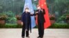 In this photo released by Xinhua News Agency, Chinese Foreign Minister Wang Yi, right, poses for photo with the United Nations High Commissioner for Human Rights Michelle Bachelet in Guangzhou, in southern China's Guangdong province, May 23, 2022.