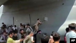 Stotine ljudi trčale su uz američki avion C-17 na pisti međunarodnog aerodroma u Kabulu, 16. avgusta 2021. Neki su bili tako očajni da su se držali za američki avion prilikom poletanja i poginuli.