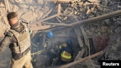 Spasioci izvlače preživele iz bombardovane zgrade škole u mestu Bilohorivka, 8. maj 2022.