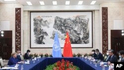 FILE - In this photo released by Xinhua News Agency, Chinese Foreign Minister Wang Yi, second right, meets with the U.N. High Commissioner for Human Rights Michelle Bachelet, left, in Guangzhou, in southern China's Guangdong province, May 23, 2022.