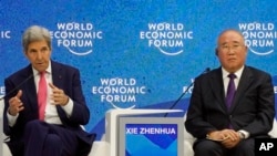 FILE - John Kerry, special U.S. presidential envoy for climate, gestures beside Xie Zhenhua, special Chinese envoy for climate change, during the World Economic Forum in Davos, Switzerland, May 24, 2022.