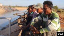 Farmers watch over an irrigation canal and as they wait to demand authorities pump more water into the irrigation system in Pursat province’s Bakan district, December 18, 2019 (Sun Narin/VOA Khmer) 