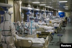 Pekerja medis dengan pakaian pelindung merawat pasien COVID-19 di unit perawatan intensif rumah sakit yang ditunjuk selama wabah COVID-19 di Wuhan, China, 6 Februari 2020. (Foto: via Reuters)