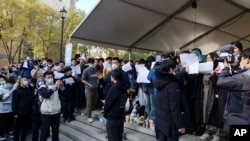 北京清华大学的学生手举白纸抗议严厉的防疫政策,悼念日前在新疆乌鲁木齐市死于火灾的至少10名遇难者。 (2022年11月27日)