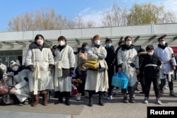 上海一家火葬场外身穿孝服的亲属为离世的亲人送行。（2023年1月4日）