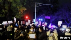 2022年11月28日,在中国北京,随着新冠肺炎疫情的持续,人们在为乌鲁木齐火灾遇难者守夜后,手持白纸抗议新冠肺炎疫情限制措施。