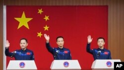 Astronot China untuk misi Shenzhou-15 mendatang, (dari kiri:) Zhang Lu, Fei Junlong dan Deng Qingming, melambaikan tangan dalam jumpa pers di Pusat Peluncuran Satelit Jiuquan di barat laut China, Senin, 28 November 2022. (Liu Lei/Xinhua via AP)