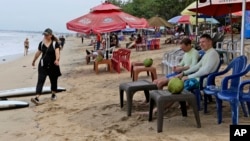 Sejumlah wisatawan terlihat di pantai Bali, 12 November 2022. Ombudsman RI menemukan bahwa data administrasi kependudukan bagi orang asing dan perubahan status kewarganegaraan masih belum terintegrasi. (Foto: Ilustrasi/AP)