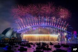 Kembang api meledak di atas Sydney Harbour Bridge saat perayaan Tahun Baru dimulai di Sydney, Australia, 1 Januari 2023. (Foto: via AP) ​
