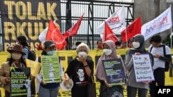Aktivis melakukan demonstrasi menentang pengesahkan KUHP di luar gedung parlemen di Jakarta. (Foto: AFP/Adek Berry)